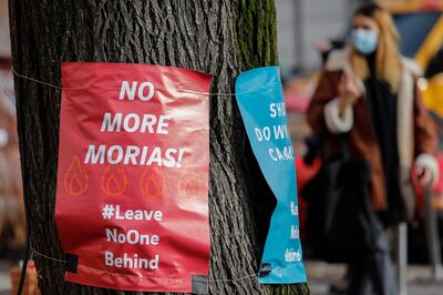 Posters calling for "No more Morias" referring to the Moria refugee camp on the Greek island of Lesbos which burned down, are hung on a tree on February 18, 2021 in Berlin's Kreuzberg district.  Lesbos' squalid Moria migrant camp was ravaged by two fires in September. It has since been replaced by a hastily-erected temporary encampment in an area prone to flooding and strong winds. Aid groups have denounced the poor conditions and the lack of infrastructure on the site, while media outlets have complained that they are banned from entering.
 / AFP / David GANNON
