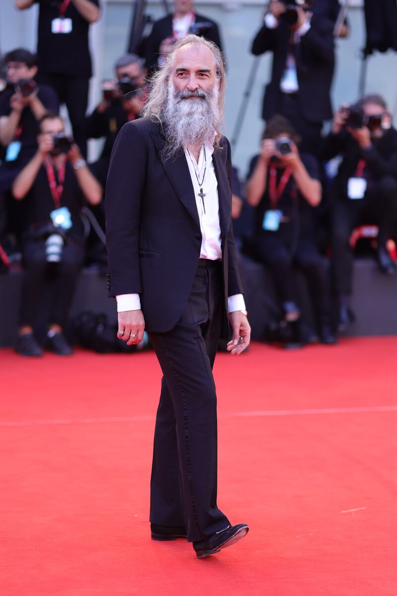 Screenwriter Warren Ellis, in a black suit with open white shirt. Getty Images