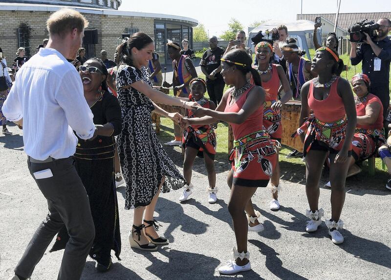 The Duke and Duchess of Sussex, Prince Harry and his wife Meghan, dance during a Justice Desk initiative in Nyanga township, on the first day of their African tour in Cape Town, South Africa, September 23, 2019. REUTERS/Toby Melville