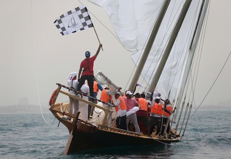 A sailor of Ghazi, a 60-foot dhow waves a flag after they won the $2.7 million Al Gaffal traditional Dhow Race. Kamran Jebreili / AP Photo
