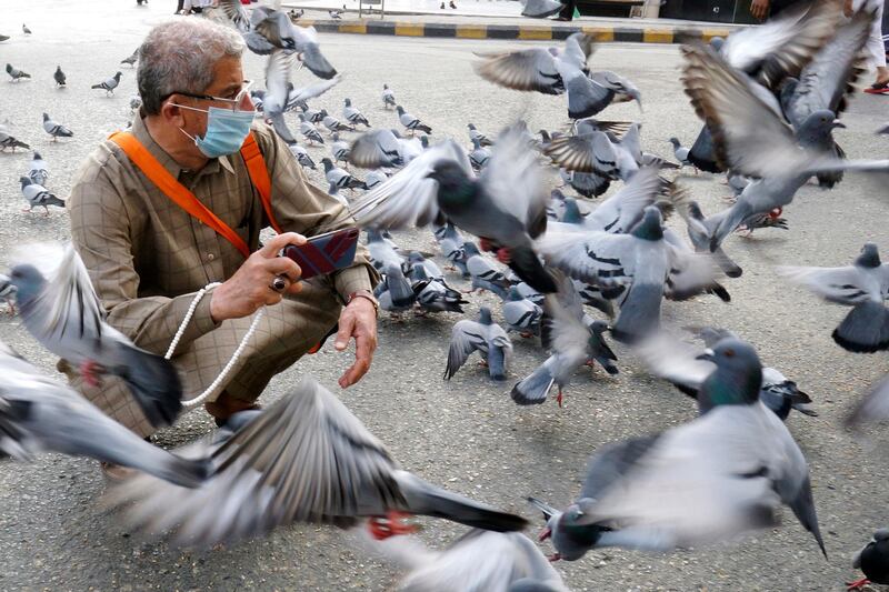 A pilgrim films pigeons outside the Grand Mosque. AP Photo