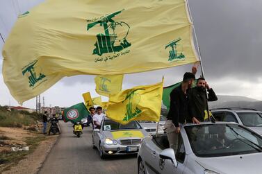 A supporter of Lebanon's Hezbollah gestures as he holds a Hezbollah flag in Marjayoun. Reuters 