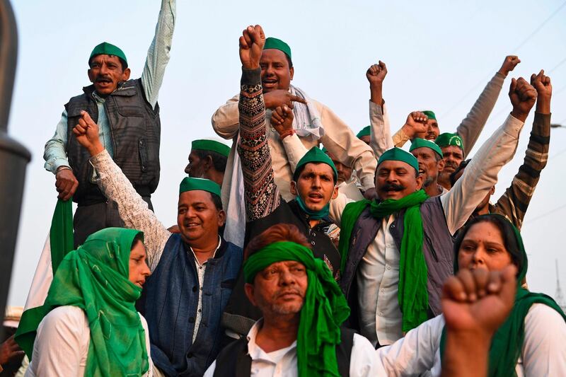 Farmers shout slogans near a police road block stopping them from marching to New Delhi to protest against the central government's recent agricultural reforms.  AFP