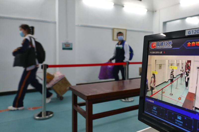 Pupils walk past a temperature-monitoring camera as they enter a high school in Wuhan in China's central Hubei province. AFP