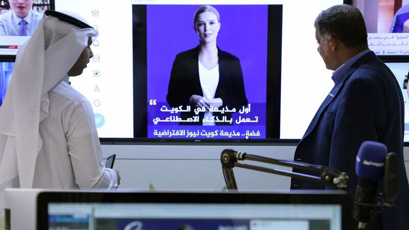Journalists watch an introductory video by the 'artificial intelligence' anchor Fedha on the twitter account of Kuwait News service, in Kuwait City on April 9, 2023.  (Photo by YASSER AL-ZAYYAT  /  AFP)