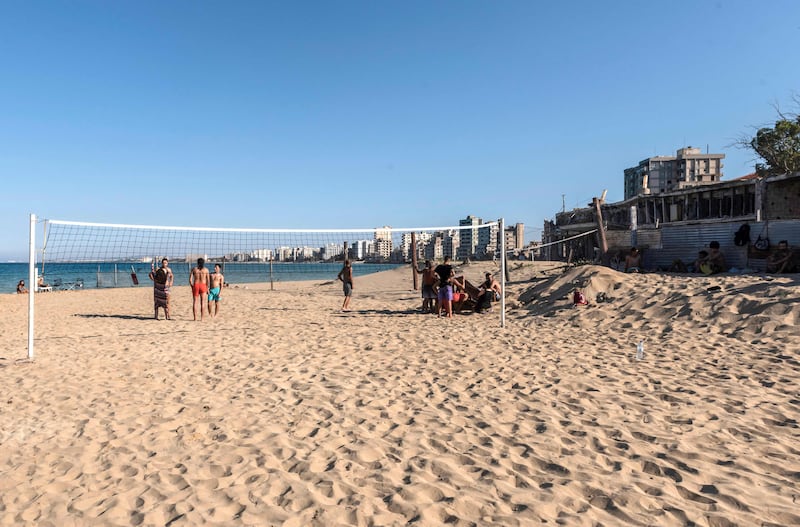 People stand on a beach volleyball court in Varosha.