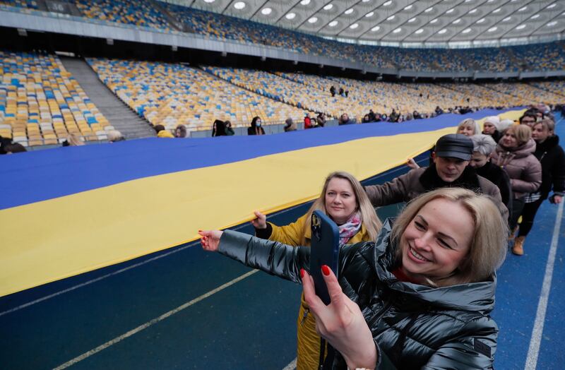 Ukrainians carry the flag around Olimpiyskiy stadium in Kiev. EPA