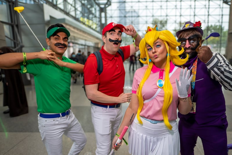 People dressed as video game characters Luigi, left, Mario, Princess Peach and Wario pose during New York Comic Con. Charles Sykes / Invision / AP