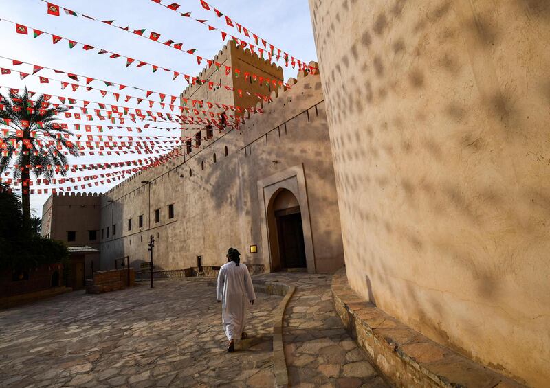 This picture taken on November 29, 2018 shows a man walking past the walls of the Nizwa Fort, a 17th-century fortification in the city of the same name, about 160 kilometres southwest of the capital Muscat.  / AFP / GIUSEPPE CACACE
