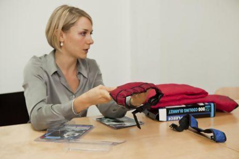 Dr Rachel Ballantyne demonstrates how to use the dog-cooling collars and mats. Antonie Robertson / The National