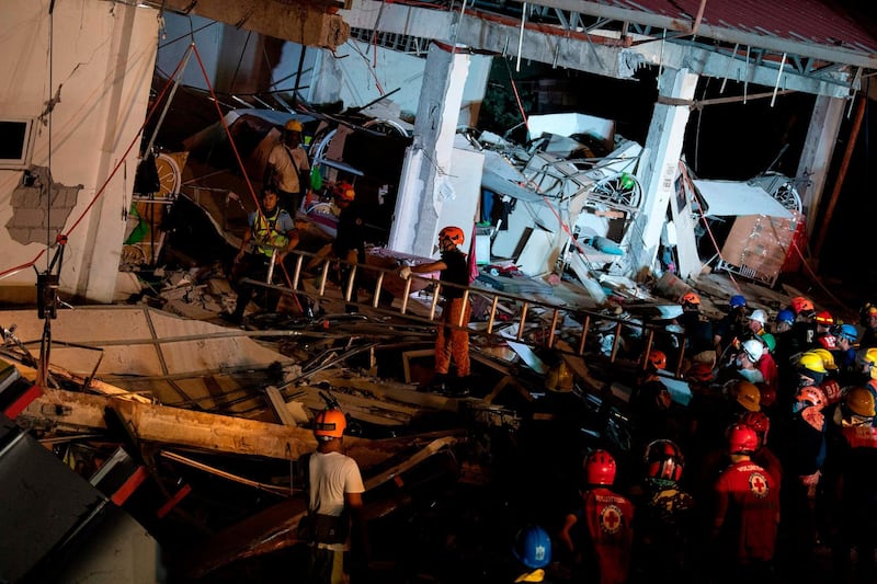 Rescue workers search for survivors in a collapsed Chuzon Super Market in Porac, Pampanga. AFP