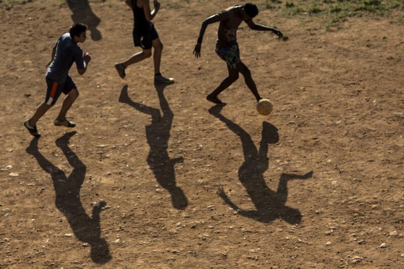 Youth play football in an empty lot that was turned into a playing field by residents on the outskirts of Havana, Cuba. Brazil will host the World Cup football tournament starting in June. Ramon Espinosa / AP 