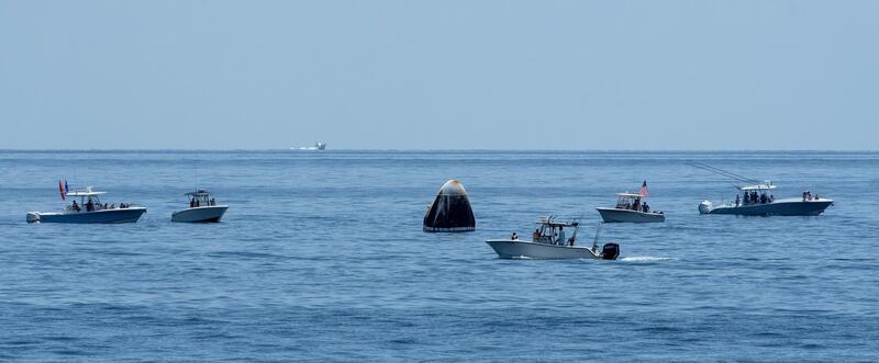 Support teams and recreational boaters arriving at the SpaceX Crew Dragon Endeavour spacecraft shortly after it landed.  EPA