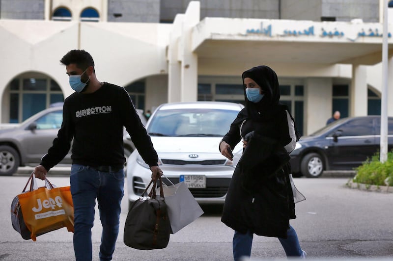 People wear face masks outside of the Rafik Hariri University Hospital where a woman is treated for coronavirus, the first case in Beirut, Lebanon.  EPA