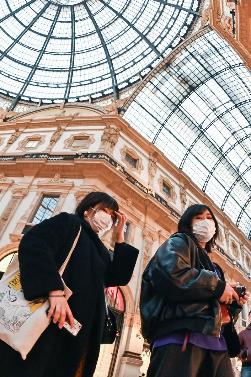 Tourists wearing protective facemasks visit the Gallery Vittorio Emanuele II, in Milan, Italy. AFP