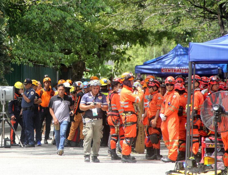 epa07961972 Filipino rescuers gather in front of a damaged residential building in the aftermath of a 6.5 magnitude earthquake, in Davao city, Philippines, 31 October 2019.'According to the United States Geological Survey (USGS), a 6.5 magnitude earthquake occurred at a depth of 10km near Bulatukan, Cotabato province, on 31 October. It is the third strong earthquake the area has experienced this month.  EPA/MIKE S. MARIANO