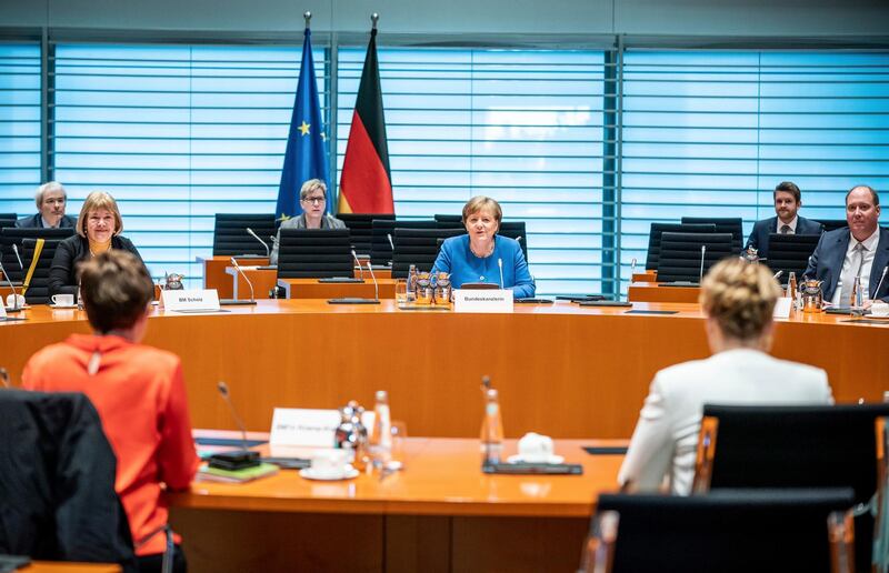 German Chancellor Angela Merkel, rear center, attends the weekly cabinet meeting at the Chancellery in Berlin, Germany, Wednesday, March 18, 2020. Due to the new coronavirus outbreak the meeting was reloacted to the International Room to provide more space between the participants.  For most people, the new coronavirus causes only mild or moderate symptoms. For some it can cause more severe illness, especially in older adults and people with existing health problems.  (Michael Kappeler/DPA via AP, Pool)
