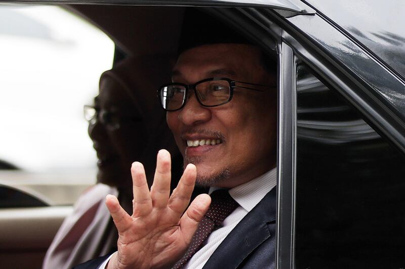 Malaysia's reformist icon Anwar Ibrahim sits inside a vehicle with his wife Wan Azizah, President of Justice Party, and waves as they leave the National Palace after meeting the king in Kuala Lumpur, Malaysia, Wednesday, May 16, 2018. Anwar has been freed from custody after receiving a pardon from the king, paving the way for a political comeback following his alliance's stunning election victory. (AP Photo/Andy Wong)