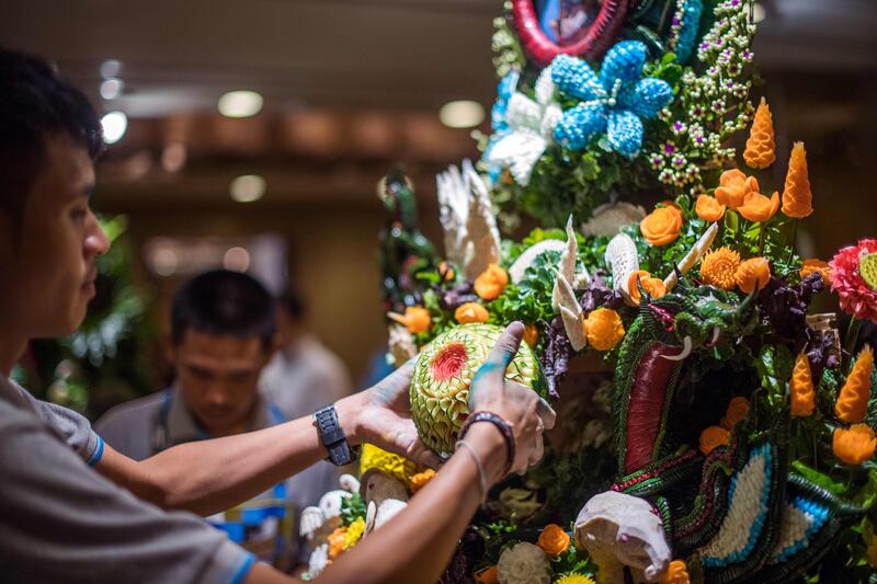 A Thai man helps put together an elaborate decoration with carved fruits and vegetables during a fruit and vegetable carving competition in Bangkok. Robert Schmidt / AFP