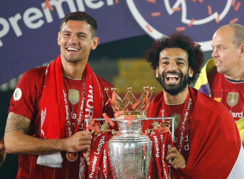 Mohamed Salah wears an Egyptian flag as he celebrates with Dejan Lovren and the trophy. Reuters