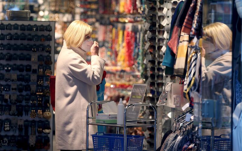 A woman wears a mask in a shop in Vienna, Austria. In an effort to slow the onset of the COVID-19 coronavirus the Austrian government restrict freedom of movement for people from Tuesday 17. AP Photo