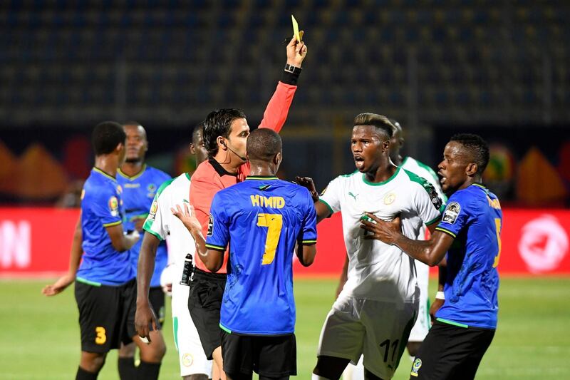 Tunisian referee Sadok Selmi shows a yellow card to Tanzania midfielder Himid Mao. AFP