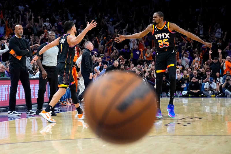 Phoenix Suns guard Devin Booker, left, celebrates a basket with forward Kevin Durant during the first half of Game 3 of an NBA basketball Western Conference semi-final against the Denver Nuggets in Phoenix, Arizona. The Suns defeated the Nuggets 121-114.  AP