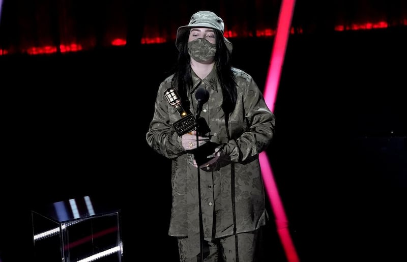 Billie Eilish accepts the award for Top Female Artist at the Billboard Music Awards wearing a khaki Gucci suit with matching face mask. AP
