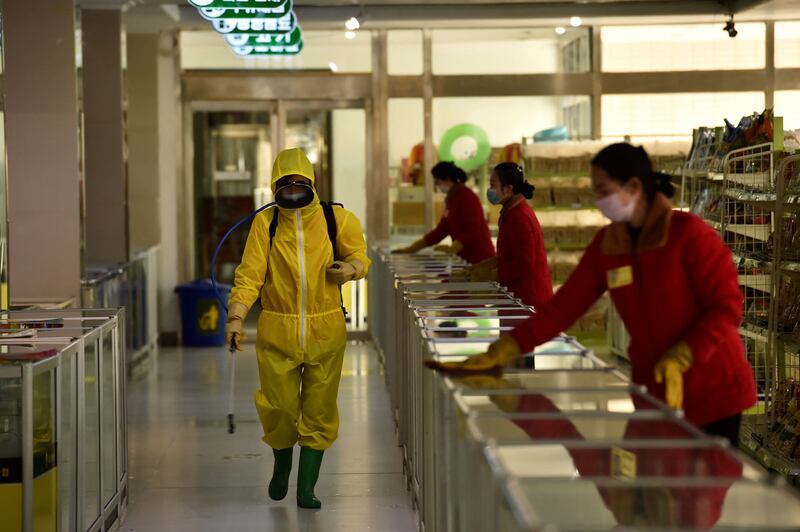 Employees disinfect surfaces at a department store in Pyongyang. AFP