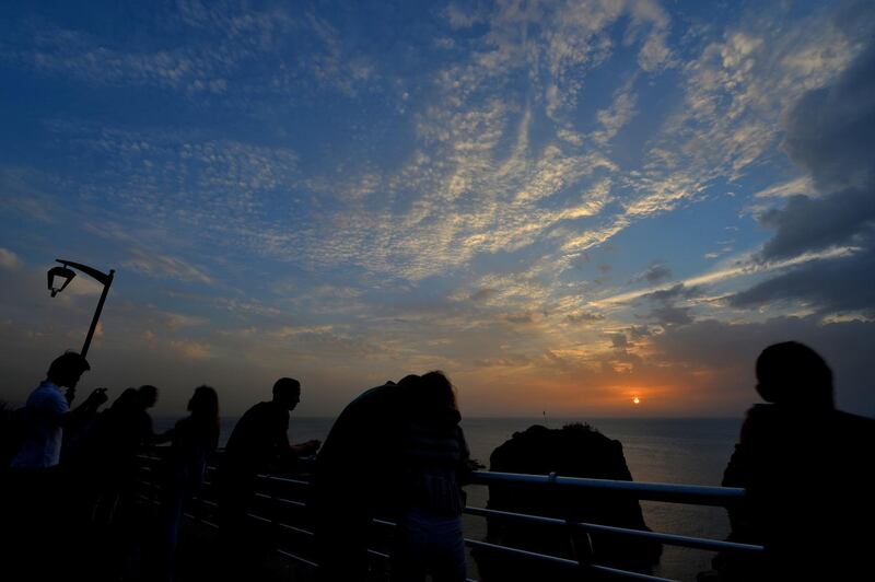 People watch the sunset overlooking the Pigeon Rocks in Beirut's Raouche district, Lebanon. EPA