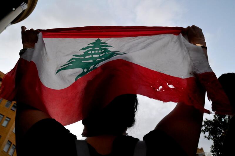 Anti-government protesters carry a national flag during a protest against former Prime Minister Saad Hariri in downtown Beirut. EPA