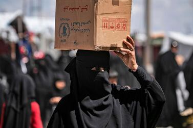 A woman displaced from Syria's eastern Deir Ezzor province carries a box in Al Hol camp for displaced people, in Hasakeh governorate in northeastern Syria on April 18, 2019. AFP