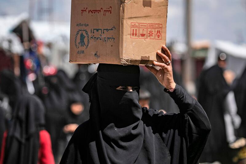 A woman displaced from Syria's eastern Deir Ezzor province,  carries a box in al-Hol camp for displaced people, in al-Hasakeh governorate in northeastern Syria on April 18, 2019.  Dislodged in a final offensive by a Kurdish-led ground force and coalition air strikes, thousands of wives and children of IS fighters have flooded in from a string of Syrian villages south of the al-Hol camp in recent months.
Among the hordes of Syrians and Iraqis, some 9,000 foreigners are held in a fenced section of the encampment, under the watch of Kurdish forces. / AFP / Delil SOULEIMAN
