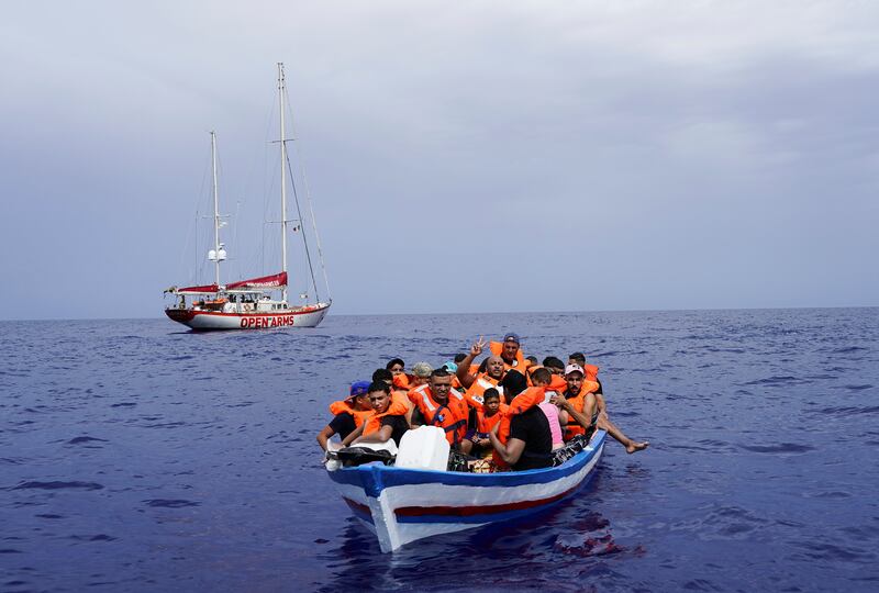 Migrants on a wooden boat wait for Italian coast guards near the island of Lampedusa in the Mediterranean Sea. Reuters