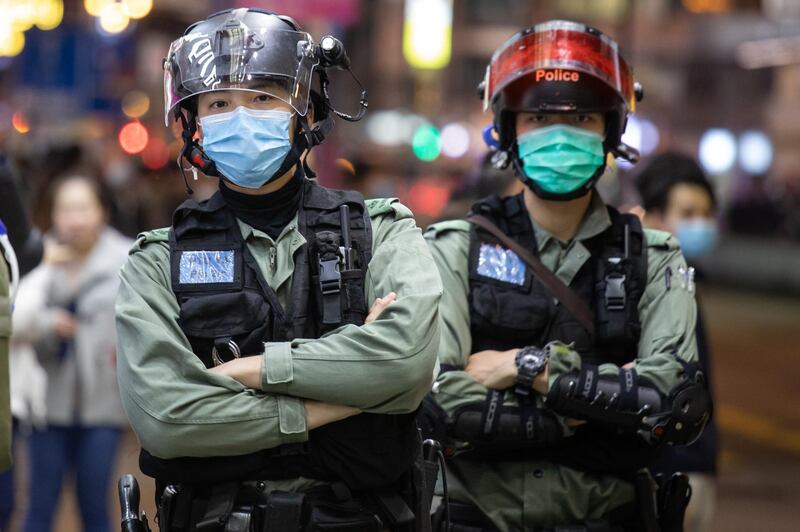 Riot police wear protective masks while standing guard on Nathan Street in the Mong Kok district of Hong Kong, China. A protest against a Hong Kong government plan to use a new and unoccupied public housing estate as a possible coronavirus quarantine facility turned violent as demonstrators set fires and destroyed some property. Bloomberg