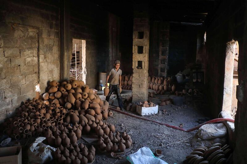 A potter arranges baked pots at a pottery in the Syrian town of Armanaz, 20 kms northwest of Idlib. AFP