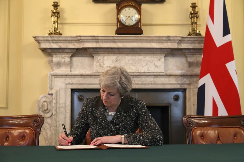 Ms May signs the official letter to European Council President Donald Tusk invoking Article 50 and the United Kingdom's intention to leave the EU, in March 2017