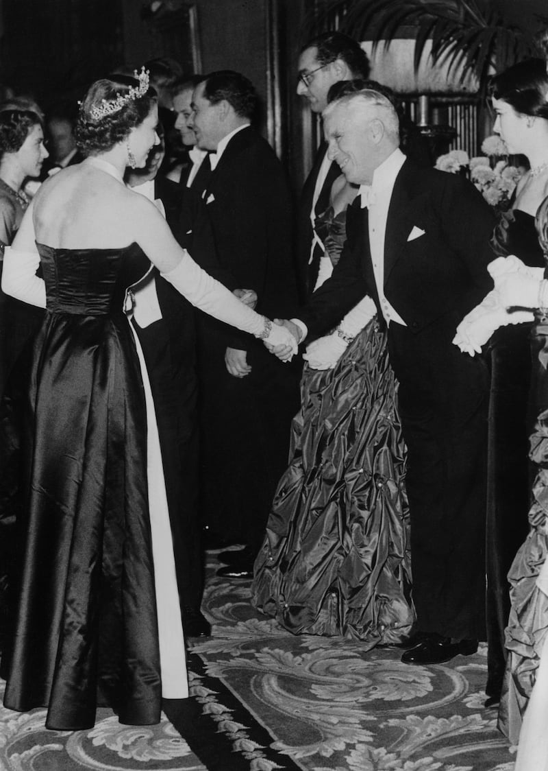 Queen Elizabeth II meets actor Charlie Chaplin at the Empire Theatre in London. Getty