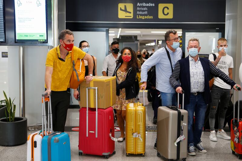 Tourists from Britain arrive at the airport in Mallorca, Spain, after England lifted quarantine requirements for travellers returning from the Balearic Islands.