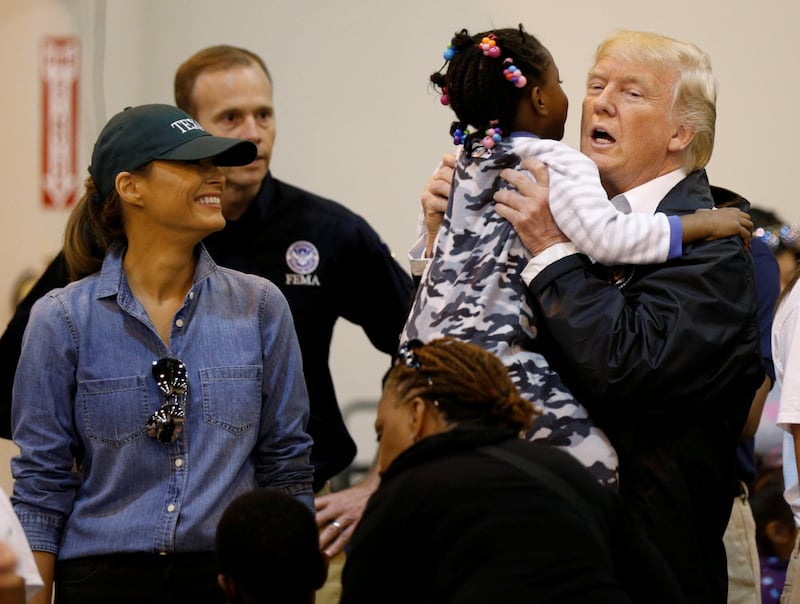 U.S. President Donald Trump lifts up a little girl as he and first lady Melania Trump visit with flood survivors of Hurricane Harvey at a relief center in Houston, Texas, U.S., September 2, 2017. REUTERS/Kevin Lamarque TPX IMAGES OF THE DAY
