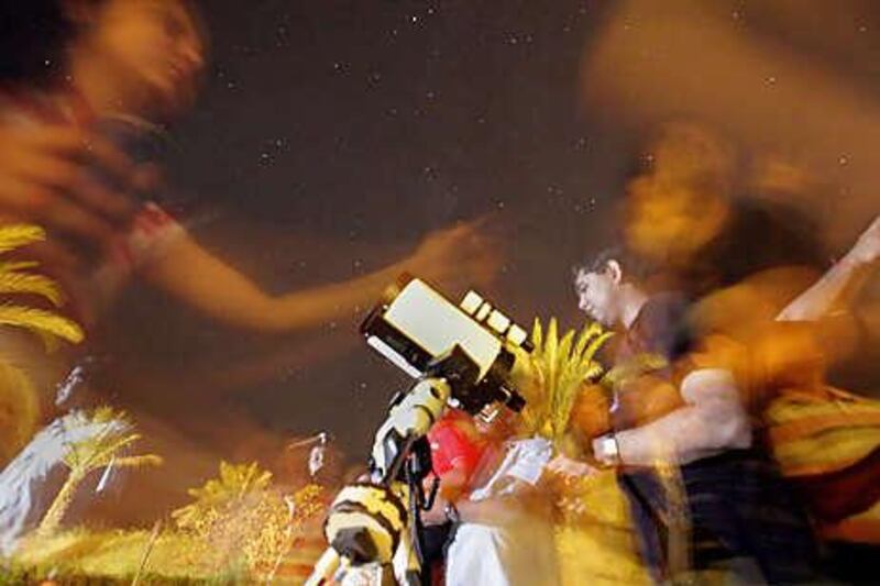 Spectators gather in the courtyard of the Bab Al Shams resort hotel in Dubai to see the annual Perseid meteor shower.