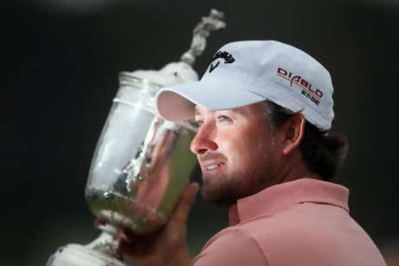 Graeme McDowell of Northern Ireland celebrates with the trophy on the 18th green after winning the 110th US Open at Pebble Beach Golf Links.