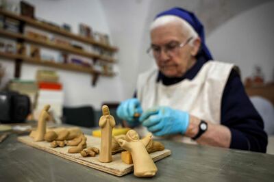 Sister Eliana, a French Catholic nun of the Little Sisters of Jesus, shapes clay figurines for sale in Bethlehem. AFP