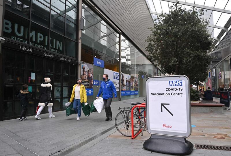 Pedestrians walk past an NHS Covid-19 vaccination centre in Westfield Stratford City shopping centre in east London. AFP