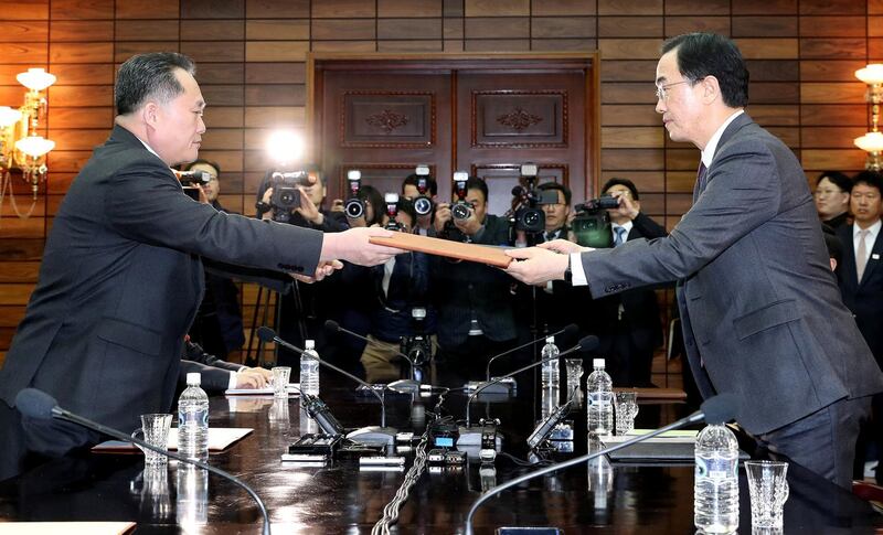 South Korean Unification Minister Cho Myoung-gyon exchanges documents with his North Korean counterpart Ri Son Gwon during their meeting at the truce village of Panmunjom, North Korea March 29, 2018. Korea Pool/Yonhap via REUTERS  ATTENTION EDITORS - THIS IMAGE HAS BEEN SUPPLIED BY A THIRD PARTY. SOUTH KOREA OUT. NO RESALES. NO ARCHIVE.