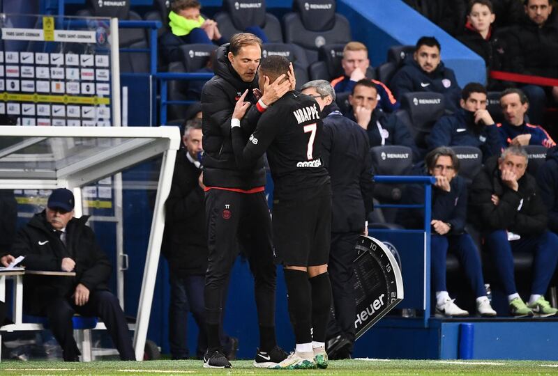 Paris Saint-Germain's French forward Kylian Mbappe speaks with coach Thomas Tuchel as he leaves the pitch. AFP