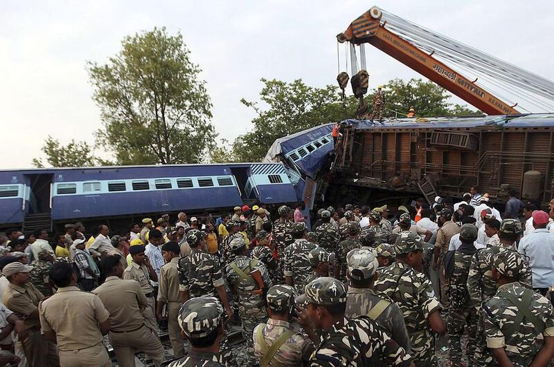 Security personnel and rescue members stand next to damaged coaches of a passenger train after a collision in Khalilabad in the northern state of Uttar Pradesh, India. Stringer / Reuters