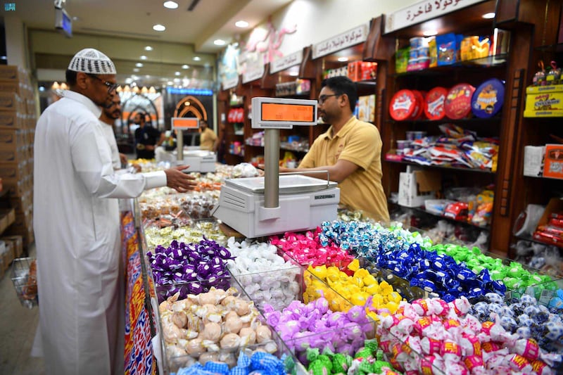 A sweets vendor in a market in Madinah welcomes customers ahead of Eid Al Fitr