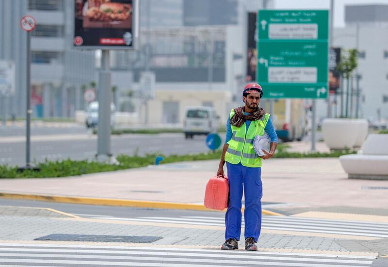 Abu Dhabi, United Arab Emirates, May 19, 2019. –Muggy weather at Al Reem Island.--  A worker crosses the street at Al Reem Island.
Victor Besa/The National
Section:  NA
Reporter: