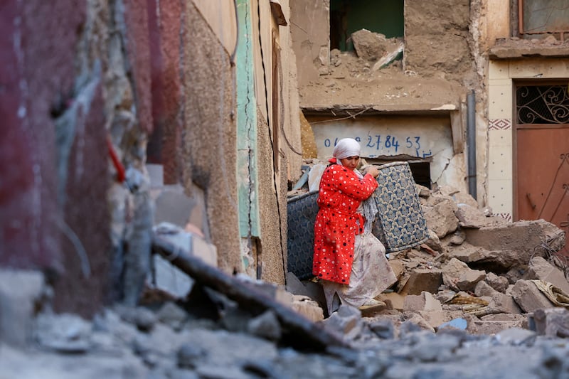 A woman carries belongings out of a damaged building in the aftermath of a deadly earthquake in Moulay Brahim, Morocco. Reuters